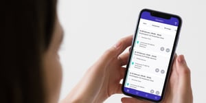 mockuuups-iphone-mockup-held-up-by-a-woman-min-min